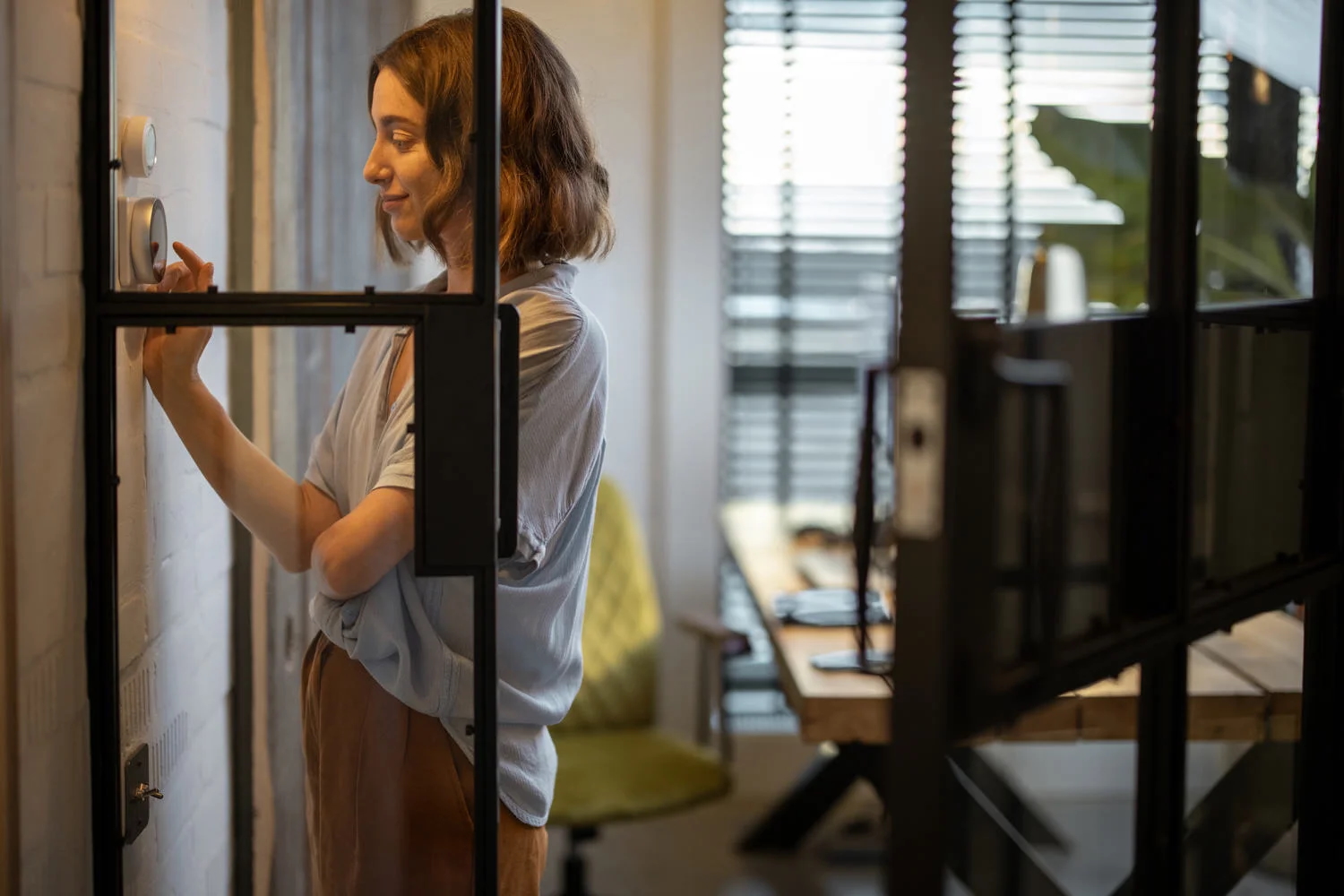 woman adjusting temperature on a wifi thermostat Sarasota AC Repair.