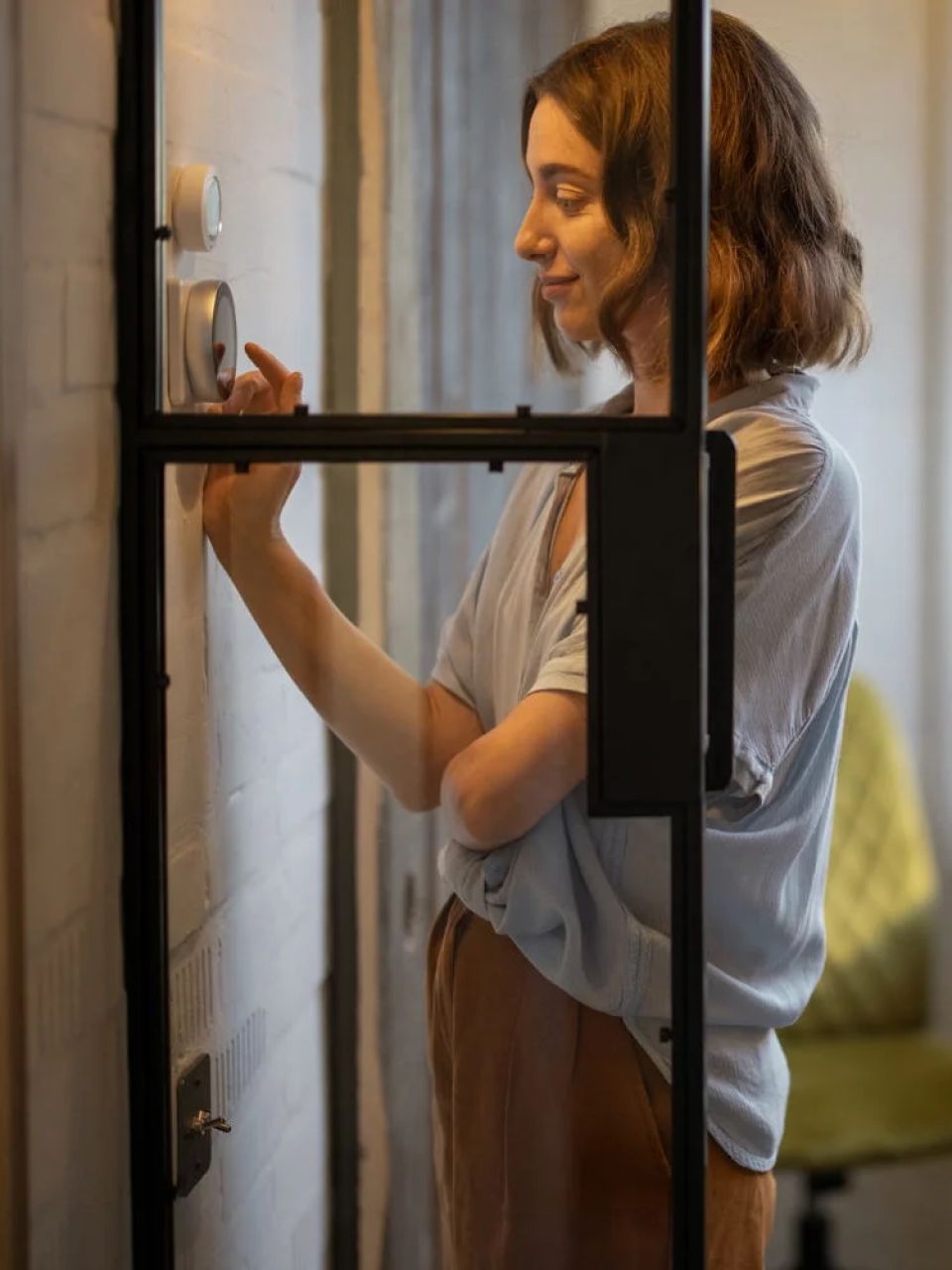 woman adjusting temperature on a wifi thermostat Sarasota AC Repair.