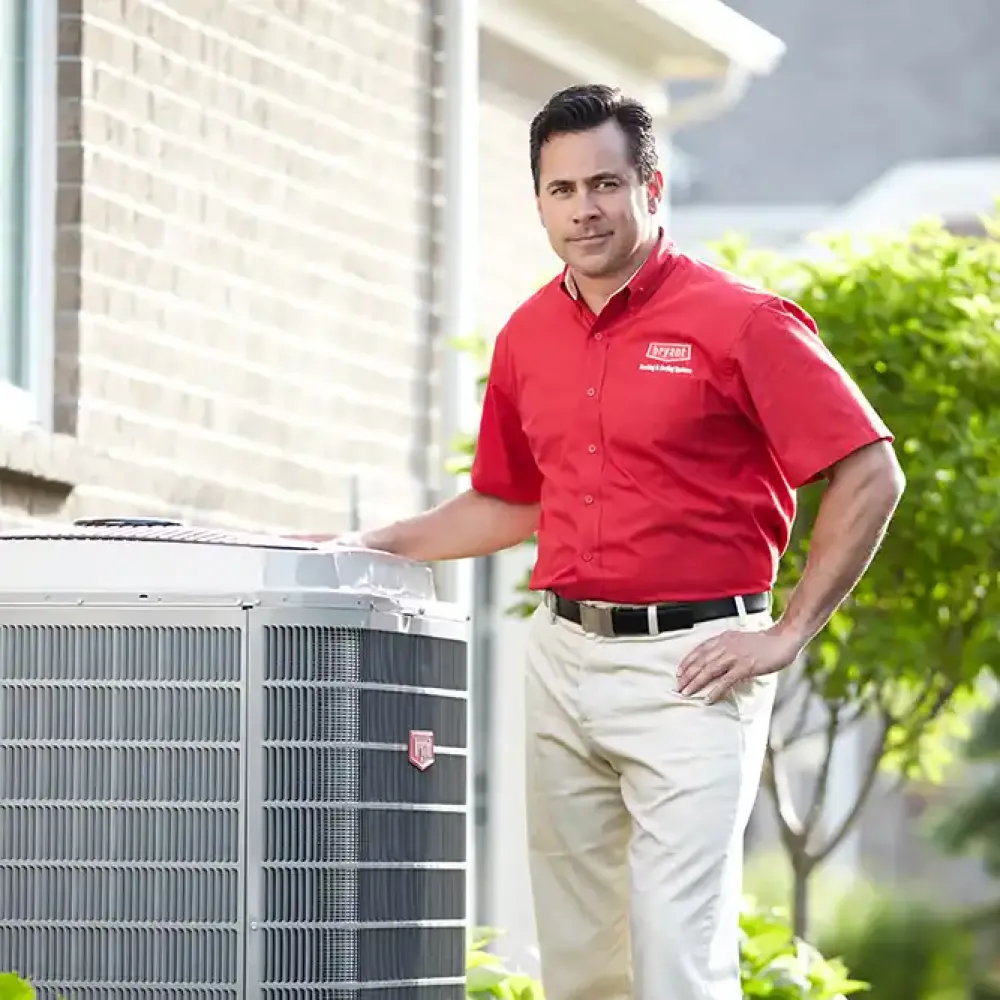 A Bryant contractor close to a air conditioning condenser unit.